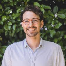 foto de um homem branco que usa óculos e que aparece do peito para cima